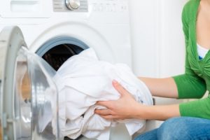 She takes the laundry out of the dryer.