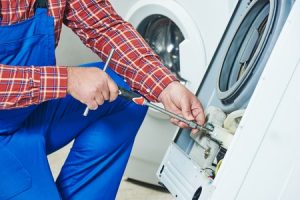 Washer technician fixing the damaged washer