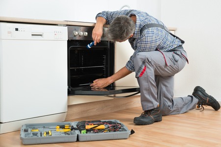 man fixing oven