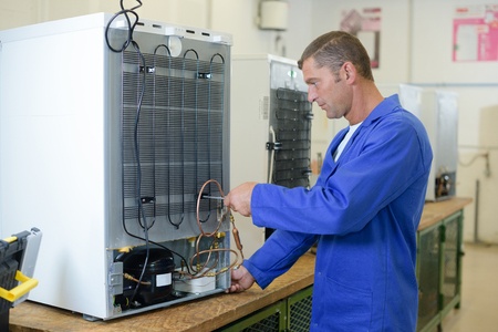 technician fixing the refrigerator