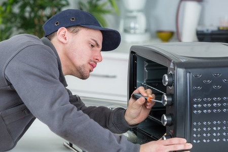 man fixing microwave