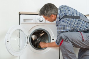 technician Checking Washing Machine At Home