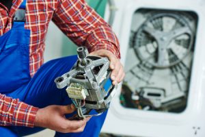 Washer repairman holding the motor