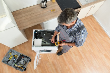 repair man checking washing machine