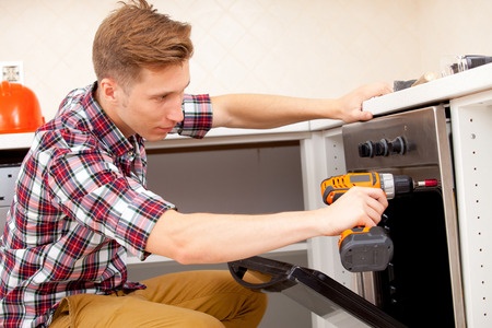 technician fixing the kitchen oven