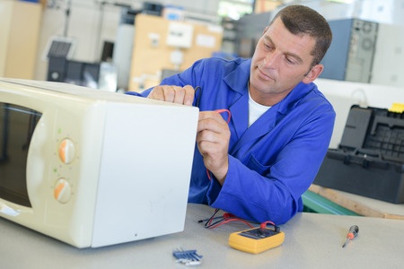 repair man checking microwave